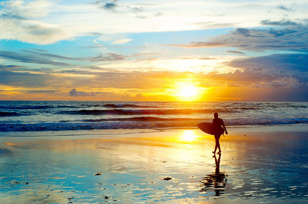 Bali-Surfer-on-the-ocean-beach-at-sunset-shutterstock_1392766821